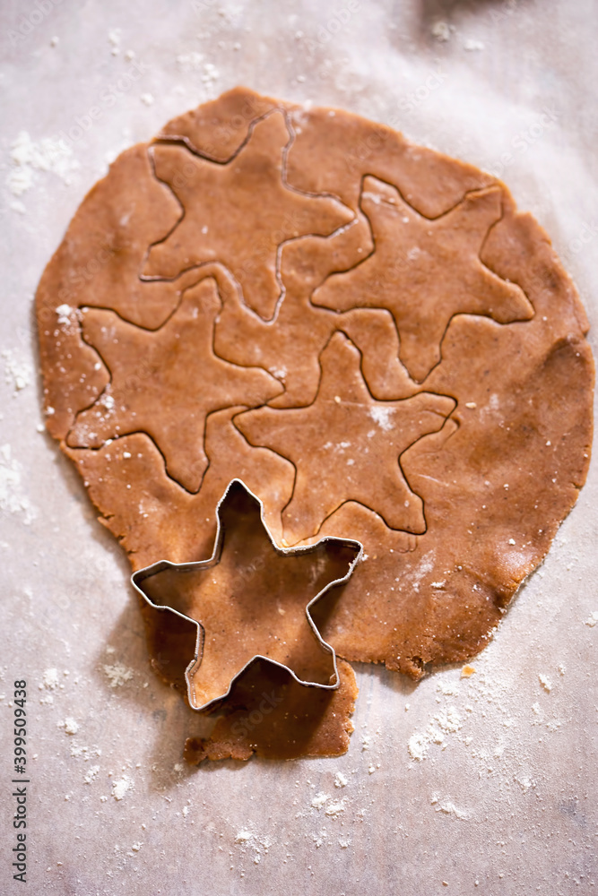 Raw rolled gingerbread dough, cutting festive shaped cookies Raw rolled gingerbread dough, cutting festive shaped cookies