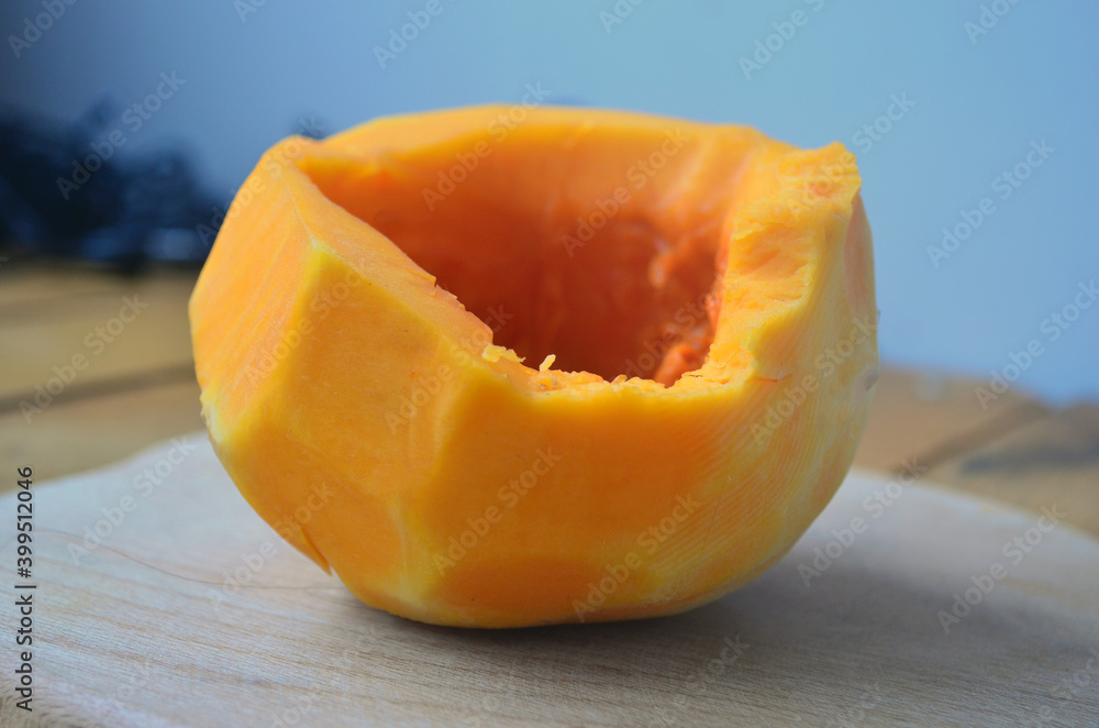 Sliced ​​orange pumpkin on a wooden board. Fresh vegetables without skin. Pieces.