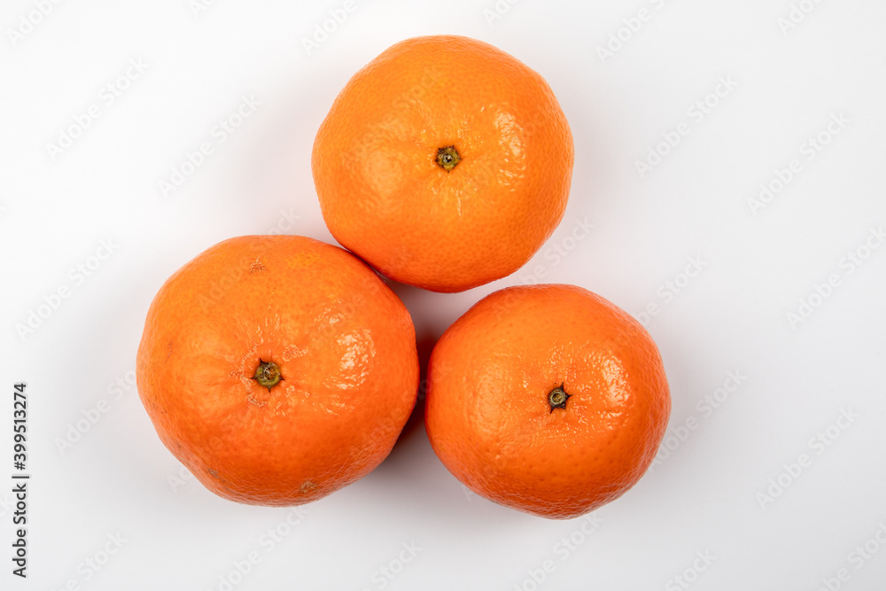 Three tangerine or mandarin fruit on a white background. Vitamins, nutrition and Christmas background Three tangerine or mandarin fruit on a white background. Vitamins, nutrition and Christmas background