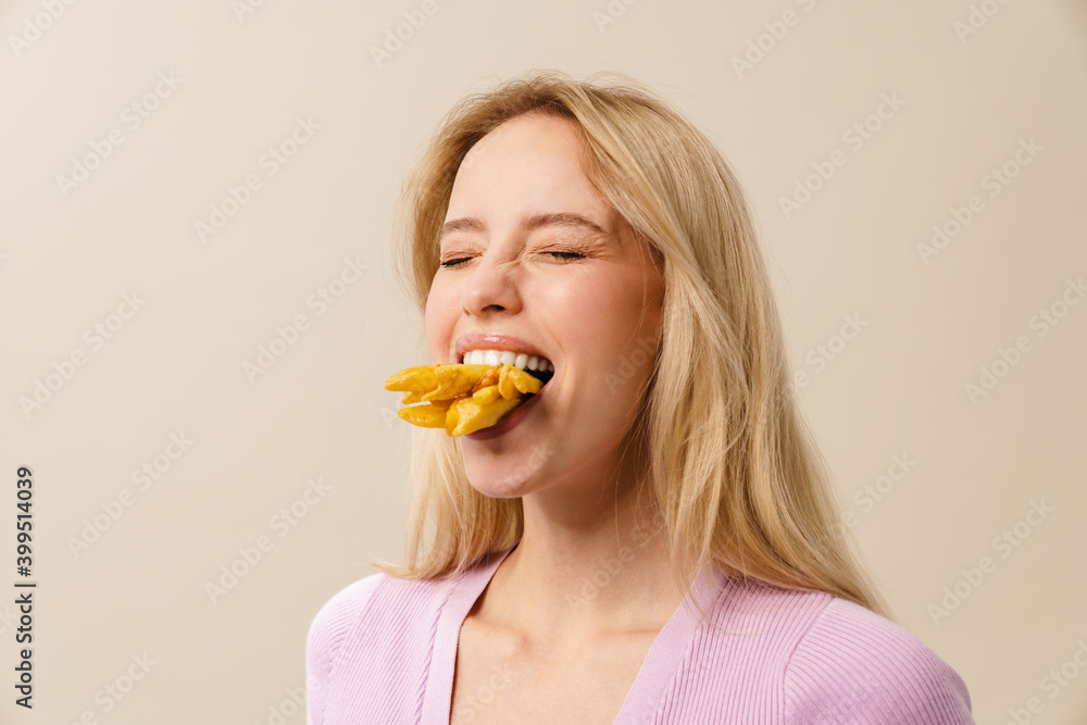 Cheerful beautiful girl posing with french fries in her mouth