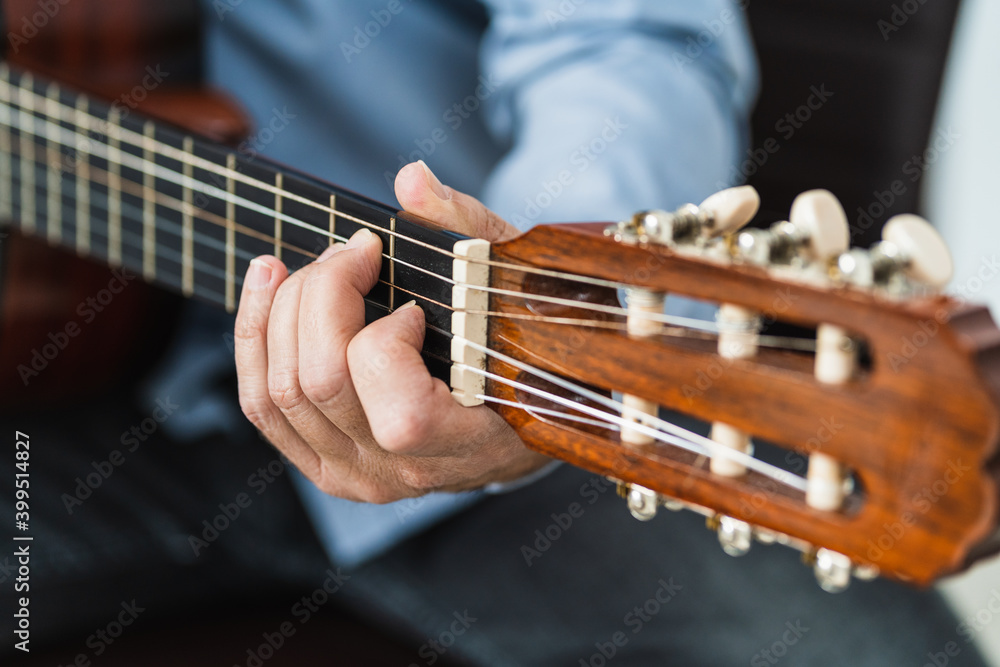 Male playing a note with the guitar