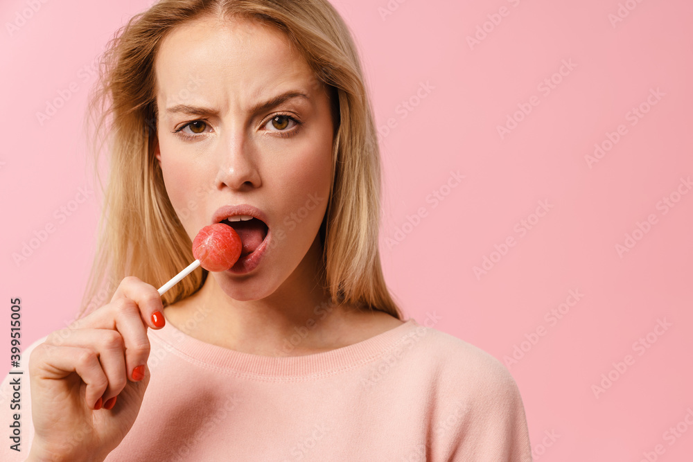 Displeased charming blonde girl liking lollipop on camera Displeased charming blonde girl liking lollipop on camera