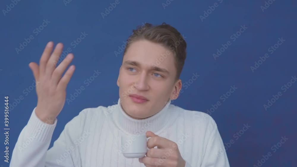 The guy in the sweater enjoys the smell of hot coffee The guy in the sweater enjoys the smell of hot coffee
