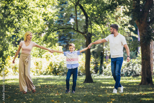 Fototapeta Naklejka Na Ścianę i Meble -  Young happy family with one children in the summer park