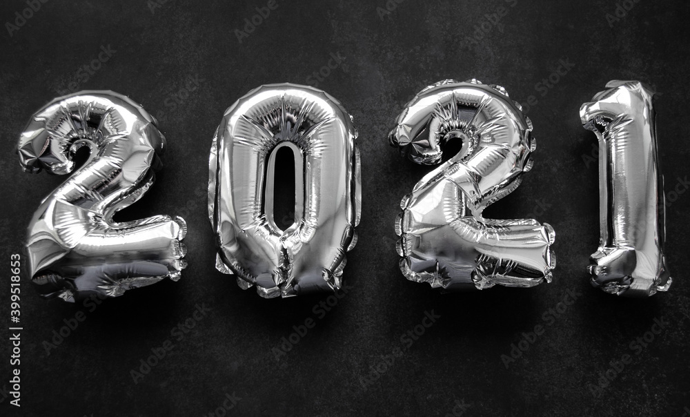 Inflatable shiny silver numbers of the new year 2021 on a dark grey or black background Inflatable shiny silver numbers of the new year 2021 on a dark grey or black background