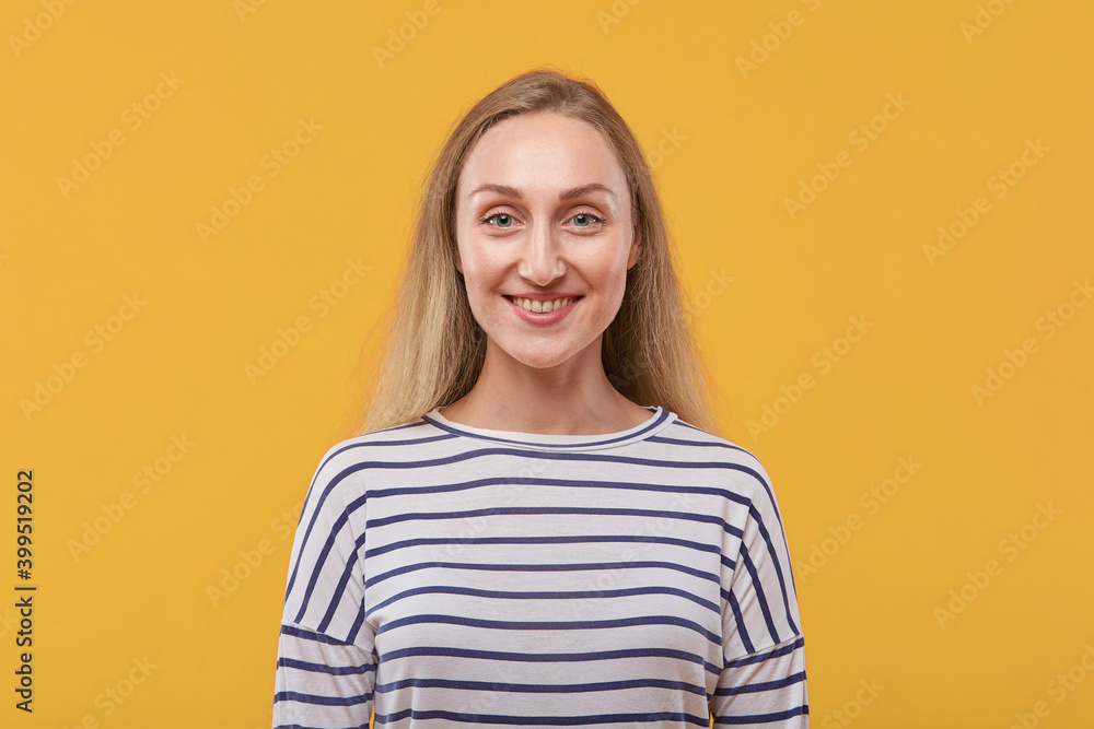 Portrait of a beautiful young blonde woman looking at the camera. Yellow background. Portrait of a beautiful young blonde woman looking at the camera. Yellow background.