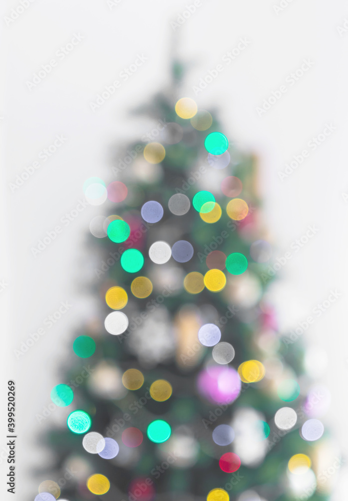 New year blurred defocused christmas tree festive background on gray with ornaments and colorful holiday lights bokeh New year blurred defocused christmas tree festive background on gray with ornaments and colorful holiday lights bokeh