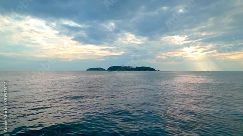 Yacht sailing across a boat, in front a small island on the sea