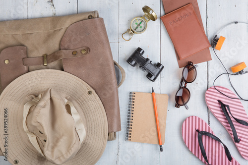 Prepare for journey in africa style - accessories and travel items, packing clothes in backpack: backpack, hat, passport, flip flops, sunglasses, compass
