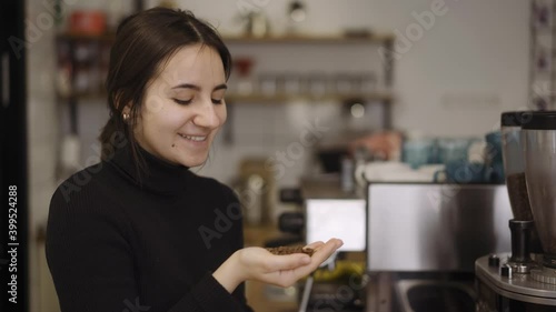 the barista nods her head with a smile on her face approving of the coffee beans in cafe photo