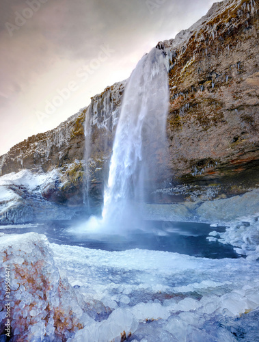 montañero en una cascada helada y rio 