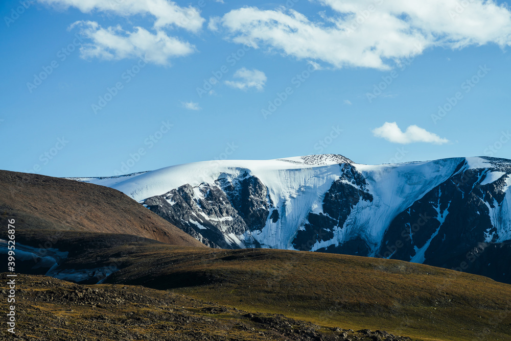 Awesome view to big snowy mountains behind green hill. Great glacier under blue sky. Wonderful vivid highland scenery with giant mountains with snow. Beautiful alpine landscape with glacial mountains. Awesome view to big snowy mountains behind green hill. Great glacier under blue sky. Wonderful vivid highland scenery with giant mountains with snow. Beautiful alpine landscape with glacial mountains.