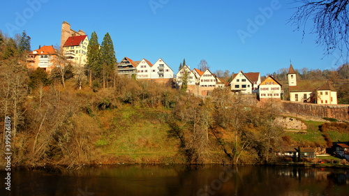 Dorf Berneck mit malerischen Häuserfronten und alter Burg auf hohem Berg über schönem See in der Sonne