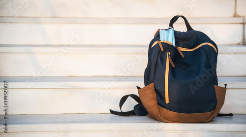 Fototapeta Naklejka Na Ścianę i Meble -  Backpack with face mask inside on stairs outdoor