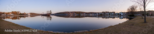 Panorama at sunrise on an early spring morning. Lake Winnipesaukee and the town of Meredith, New Hampshire, USA.