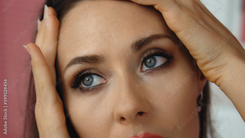 Young and beautiful European girl close-up touches the skin of the face with tender hands Young and beautiful European girl close-up touches the skin of the face with tender hands