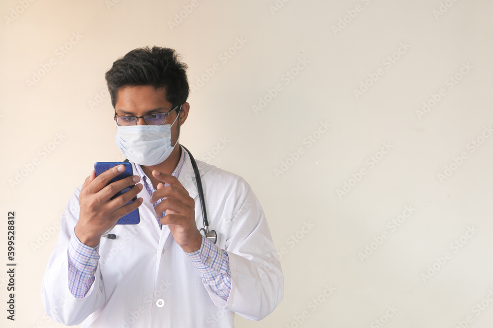 young doctor in face mask using smart phone indoor young doctor in face mask using smart phone indoor