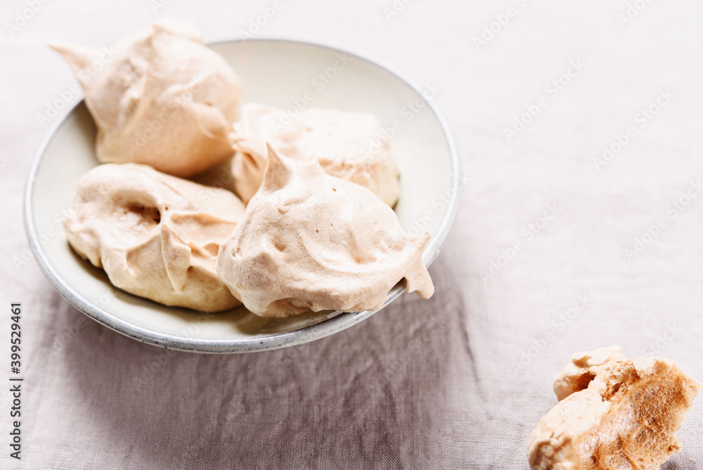 Homemade sweet meringue cookies on greige linen tablecloth. Delicious and light dessert. Selective focus Homemade sweet meringue cookies on greige linen tablecloth. Delicious and light dessert. Selective focus