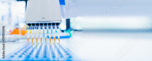 Medical and scientific banner with free space. 8-channel pipette and 96-well test plate. Genetic laboratory research technician. medical research laboratory. purification of DNA samples. photo