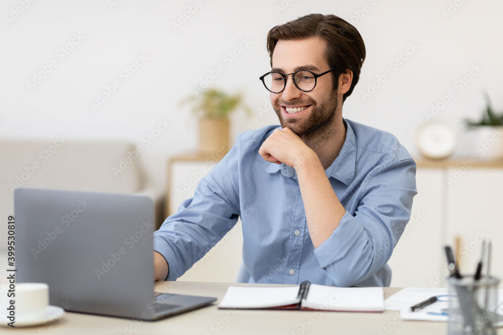 Smiling Businessman Working On Laptop Sitting At Desk In Office Smiling Businessman Working On Laptop Sitting At Desk In Office