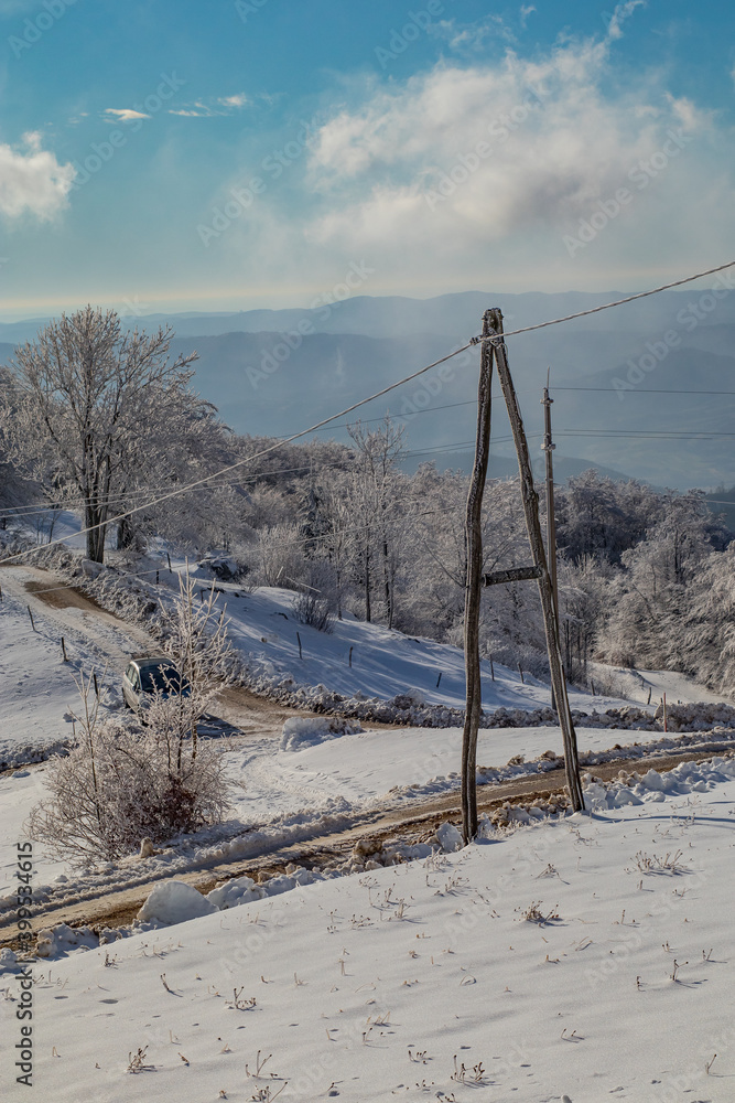 Cold nature covered with snow, with visible sole electric pole defying winds and cold weather. Rural telecommunications. Cold nature covered with snow, with visible sole electric pole defying winds and cold weather. Rural telecommunications.