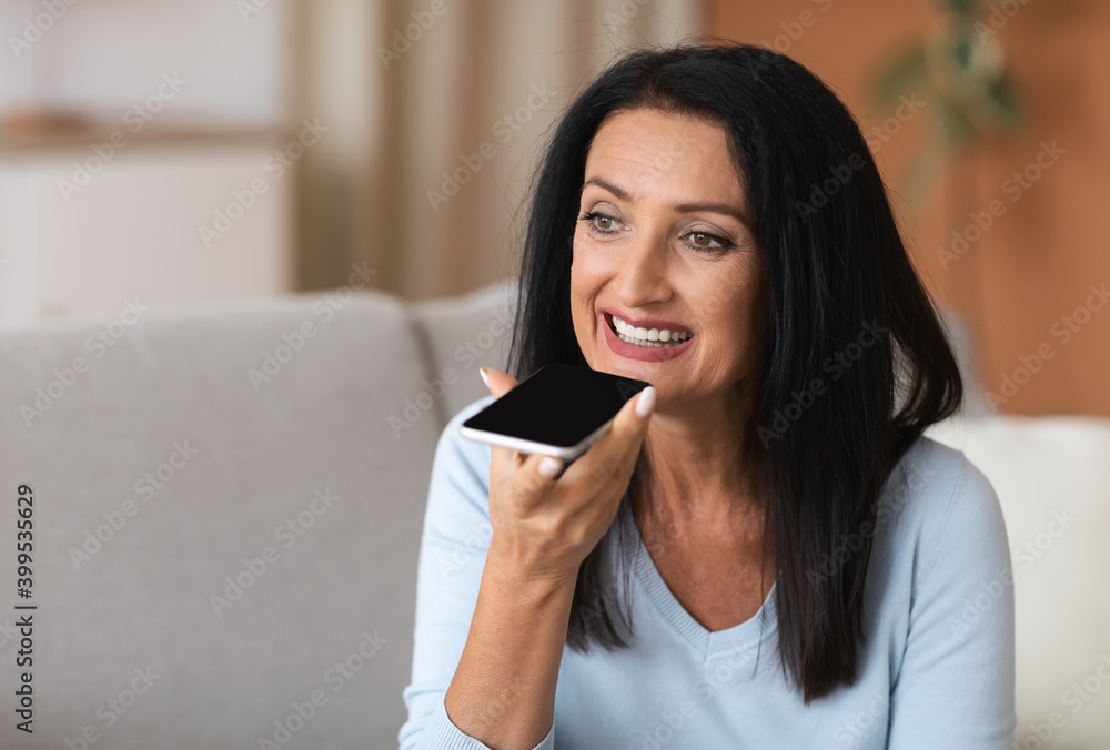 Mature woman using voice assistant on her smartphone Mature woman using voice assistant on her smartphone