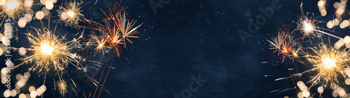 Silvester background banner panorama long- firework and sparklers on rustic dark blue night sky texture photo