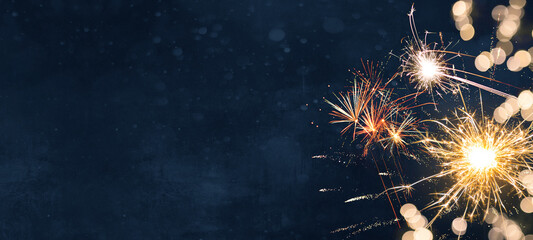 Silvester, New Year's Eve,  Festival Party New Year 2026, new years eve Fireworks background banner panorama - firework and sparklers on rustic dark blue night sky texture