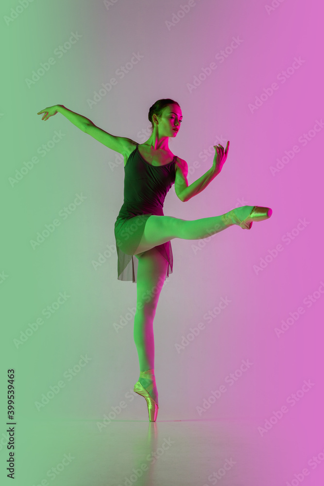Directive. Young and graceful ballet dancer isolated on gradient pink-green studio background in neon. Art, motion, action, flexibility, inspiration concept. Flexible ballerina, weightless jumps. Directive. Young and graceful ballet dancer isolated on gradient pink-green studio background in neon. Art, motion, action, flexibility, inspiration concept. Flexible ballerina, weightless jumps.