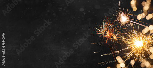 Silvester New Year 2024 background banner panorama long- firework and sparklers on dark black night texture, with space for text photo