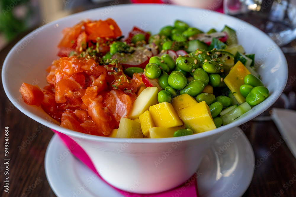 Salmon poke with avocado and mango, seaweed, pickled carrots, cucumber