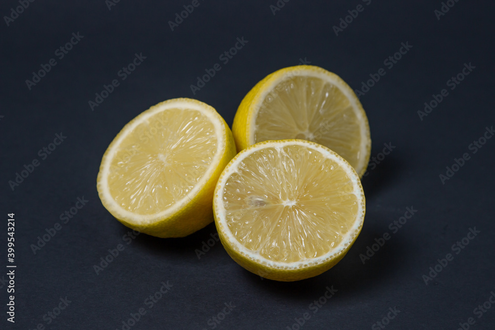 Lemons on a black background. Citrus fruit. Healthy food. Sliced lemon. Sour fruit Lemons on a black background. Citrus fruit. Healthy food. Sliced lemon. Sour fruit