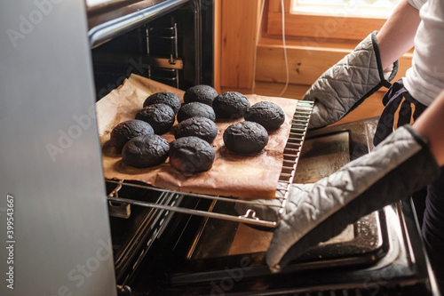 Fotografie Failed cooking in oven. Woman holding a tray of spoiled muffins