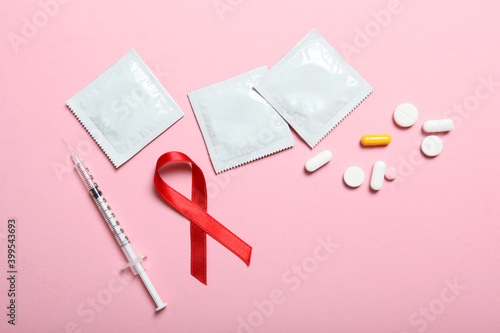Quadro em tela Condoms and red ribbon symbolizing AIDS. World AIDS Day