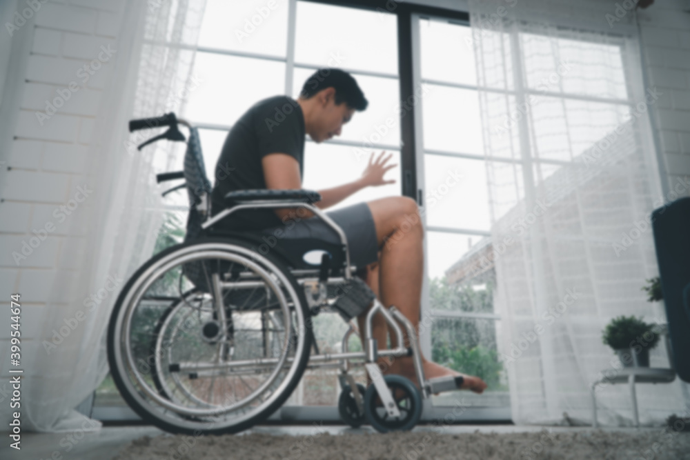 Obraz premium A disabled man sitting in a wheelchair is disappointed and Desperate to heal after car accident. Concept of Careless Driving, Insurance and Mental health care After the accident