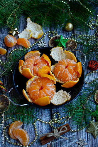 Christmas concept. Juicy tangerines on a wooden background with fir branches and decor, top view.