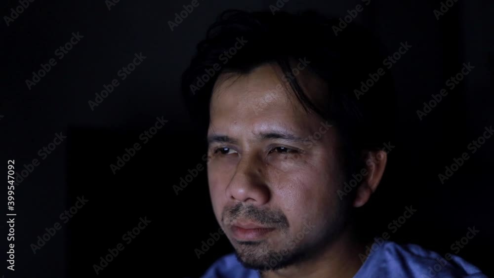 young asian man suffering headache in the dark at night young asian man suffering headache in the dark at night