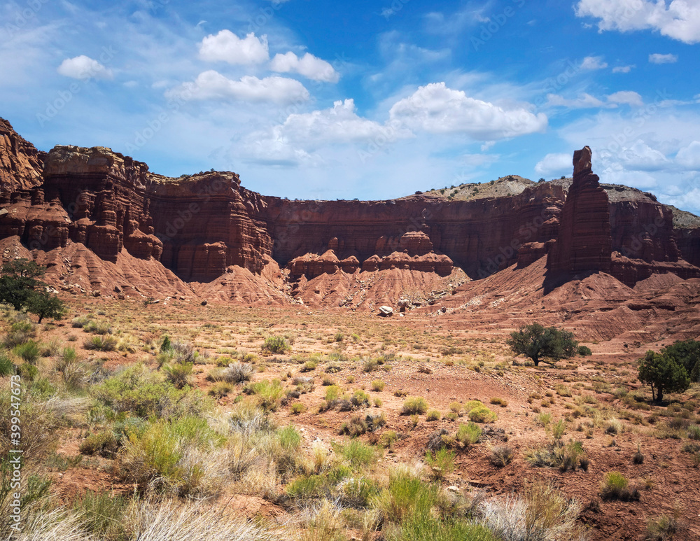 Amazing sandstone monoliths in a barren desert prairie on a blue partly cloudy summer day at Capitol Reef National Park in Torrey Utah Amazing sandstone monoliths in a barren desert prairie on a blue partly cloudy summer day at Capitol Reef National Park in Torrey Utah