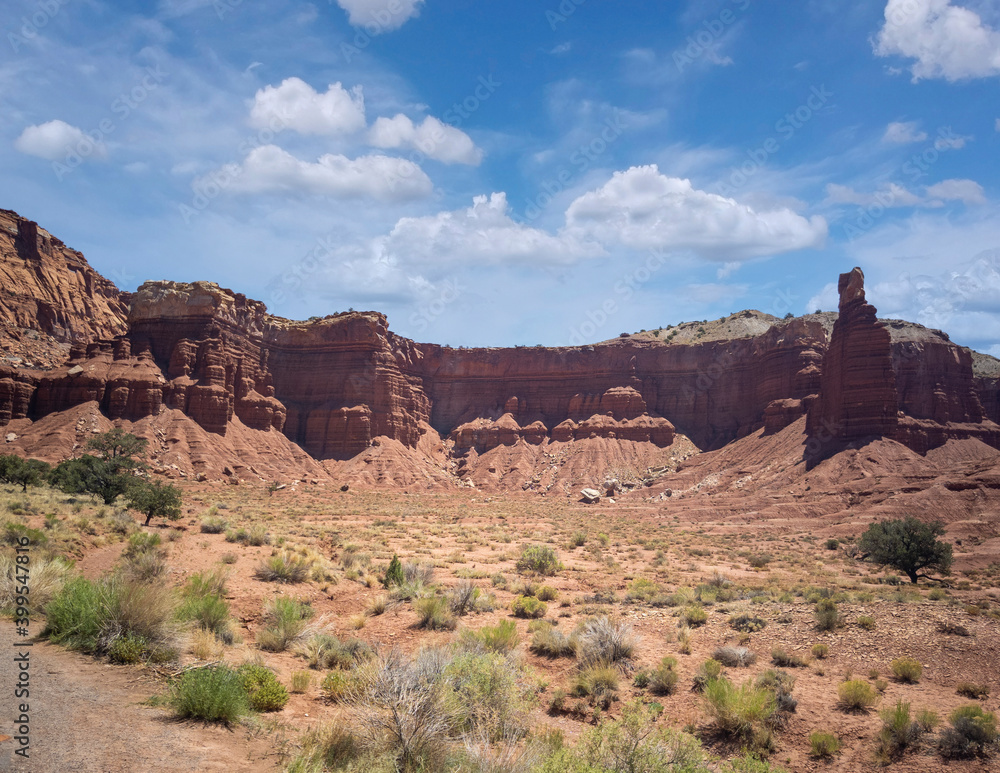 Amazing sandstone monoliths in a barren desert prairie on a blue partly cloudy summer day at Capitol Reef National Park in Torrey Utah Amazing sandstone monoliths in a barren desert prairie on a blue partly cloudy summer day at Capitol Reef National Park in Torrey Utah