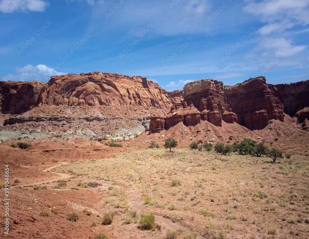 Amazing sandstone monoliths in a barren desert prairie on a blue partly cloudy summer day at Capitol Reef National Park in Torrey Utah Amazing sandstone monoliths in a barren desert prairie on a blue partly cloudy summer day at Capitol Reef National Park in Torrey Utah