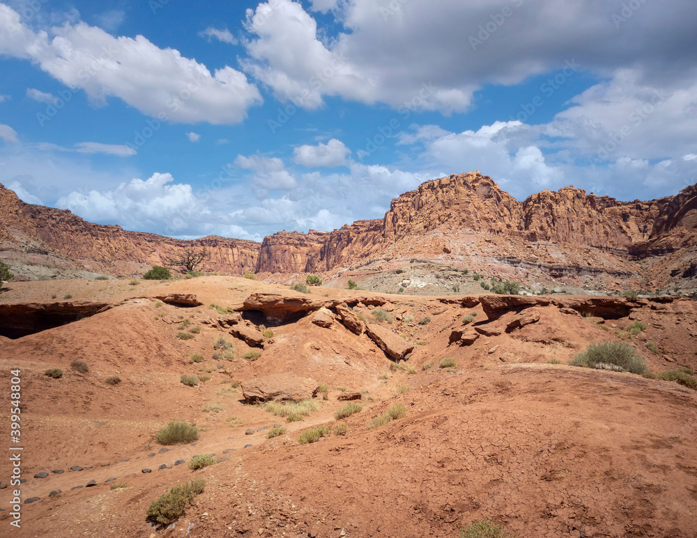 Amazing sandstone monoliths in a barren desert prairie on a blue partly cloudy summer day at Capitol Reef National Park in Torrey Utah Amazing sandstone monoliths in a barren desert prairie on a blue partly cloudy summer day at Capitol Reef National Park in Torrey Utah