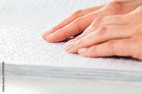 A woman reads a book written in Braille.