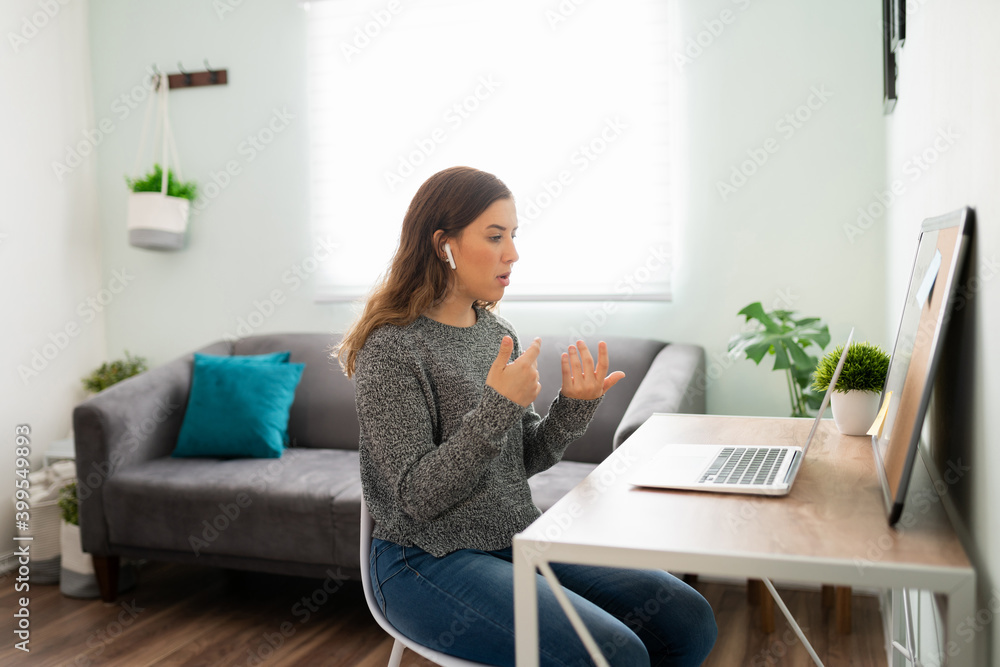 Woman talking on a work video call at her home desk Woman talking on a work video call at her home desk