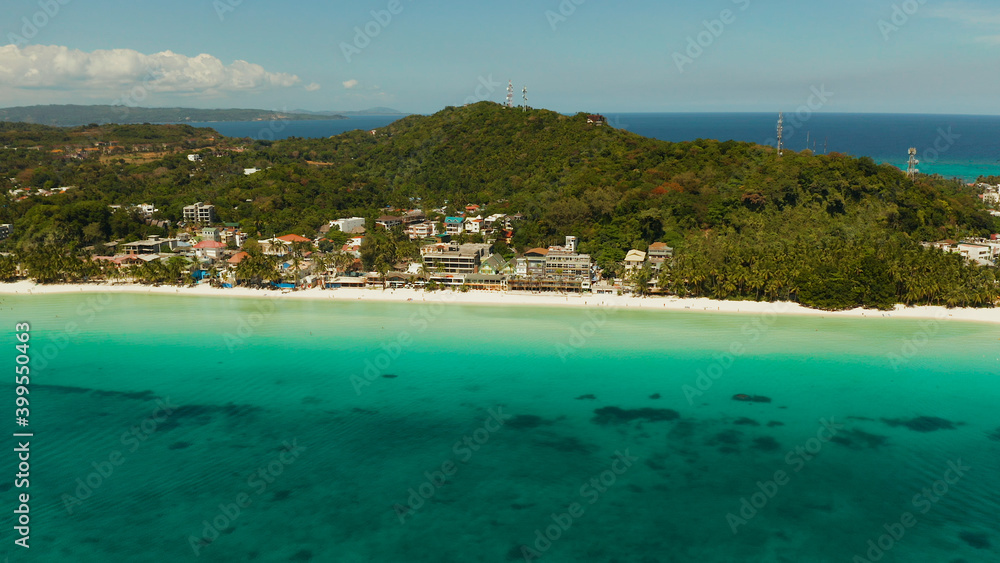 Sandy beach and turquoise water in the tropical resort of Boracay, Philippines. White beach with tourists and hotels. Summer and travel vacation concept.