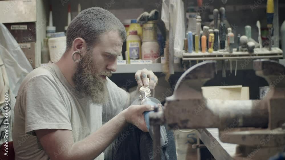 Woodworking. Professional carpenter shaping and designing a wooden workpiece with a manual engraver Woodworking. Professional carpenter shaping and designing a wooden workpiece with a manual engraver