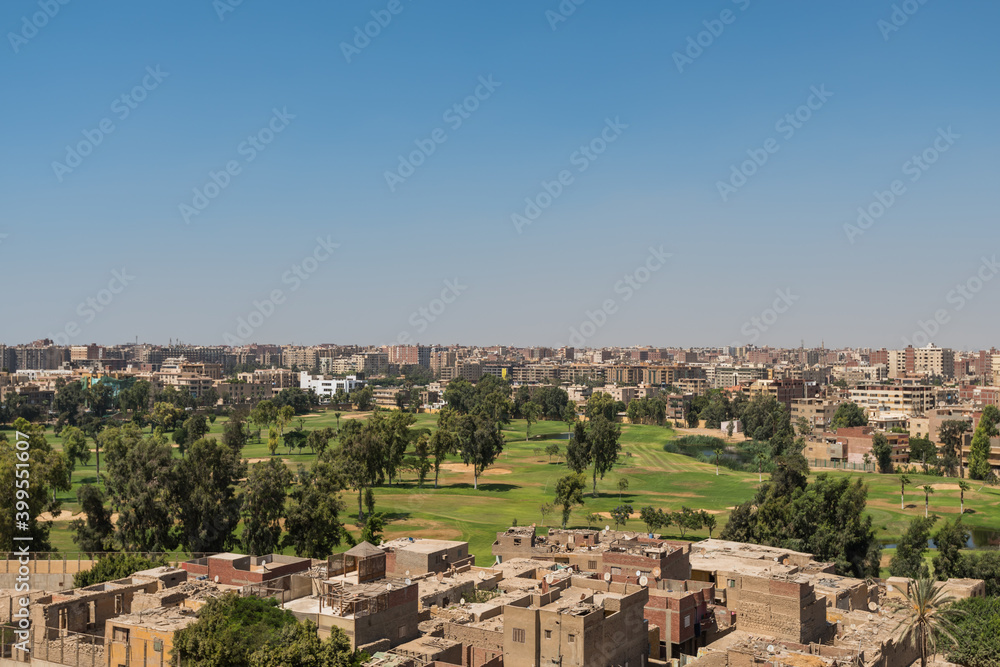 Aerial view of Cairo of red brick houses from the Giza pyramid complex,  the Giza Necropolis,  on the Giza Plateau in Greater Cairo, Egypt