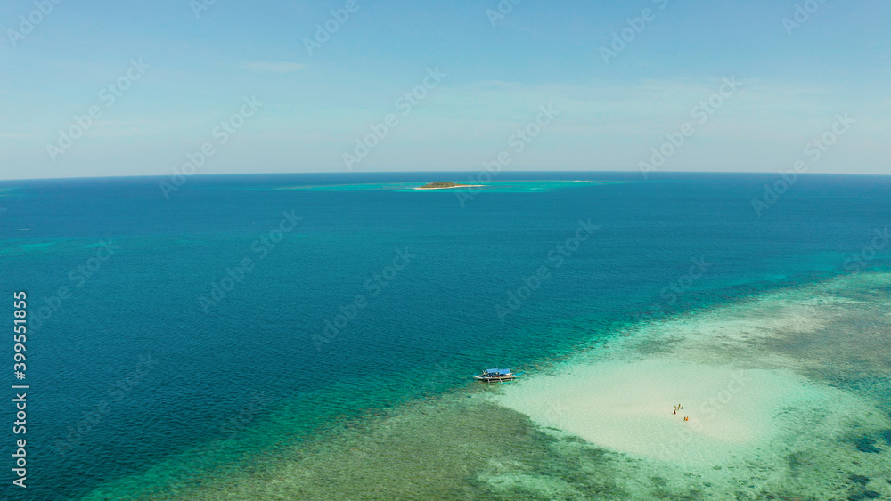 Sandy beach with tourists on a coral atoll in turquoise water, from above. Summer and travel vacation concept. Balabac, Palawan, Philippines.