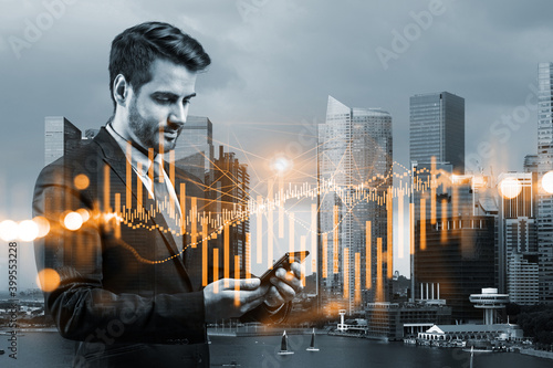 Handsome Caucasian trader checking quotes to forecast the capital market behavior. Concept of trading strategy. Forex chart. Singapore. Double exposure.