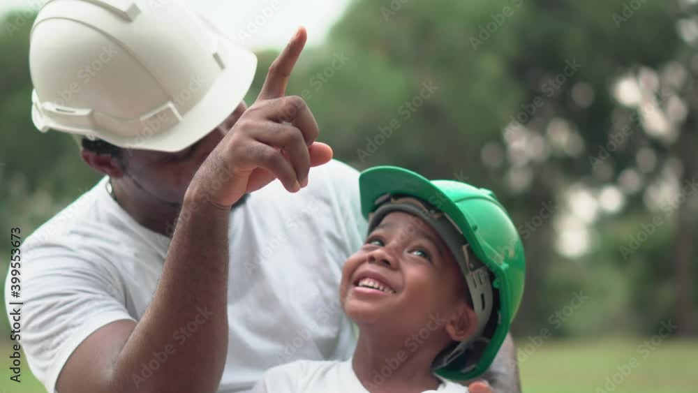 Cheerful african american father and son in hard hat playing in park, Happiness family concepts, parent and child play in park Cheerful african american father and son in hard hat playing in park, Happiness family concepts, parent and child play in park