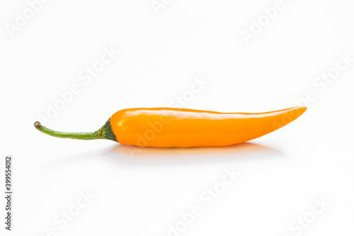 Closeup orange color chilli on white background, fresh hot chilli, organic vegetable, spicy food symbol